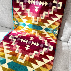 patura reversibila din lana de alpaca chimborazo model curcubeu, asezata
