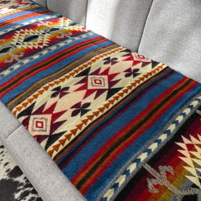 Patura reversibila din lana de alpaca Cotopaxi, aranjata pe canapea