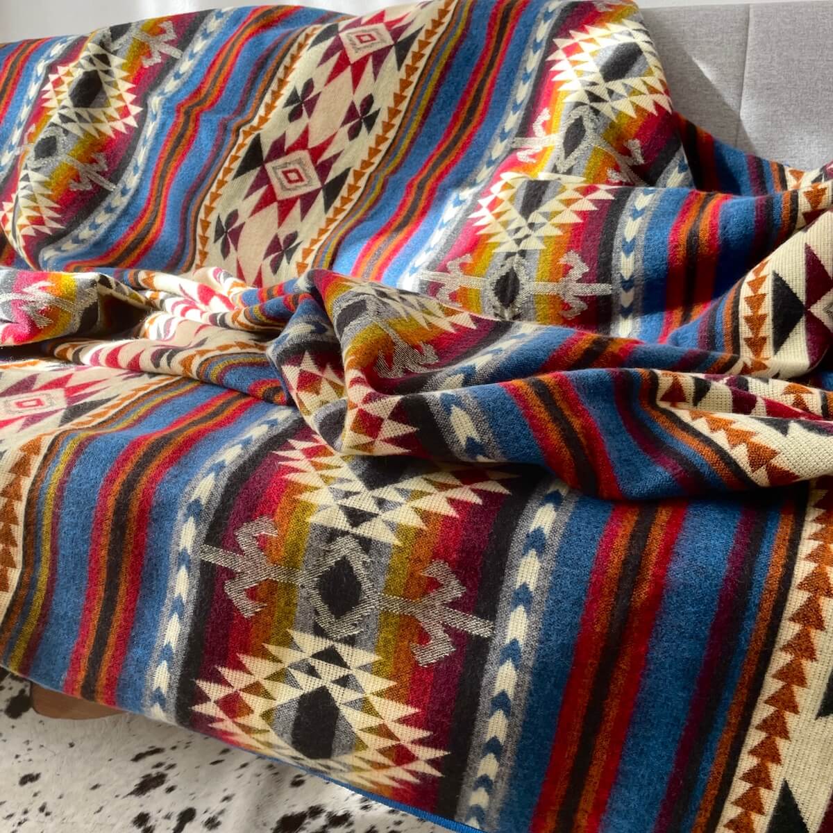 Patura reversibila din lana de alpaca Cotopaxi, pe canapea