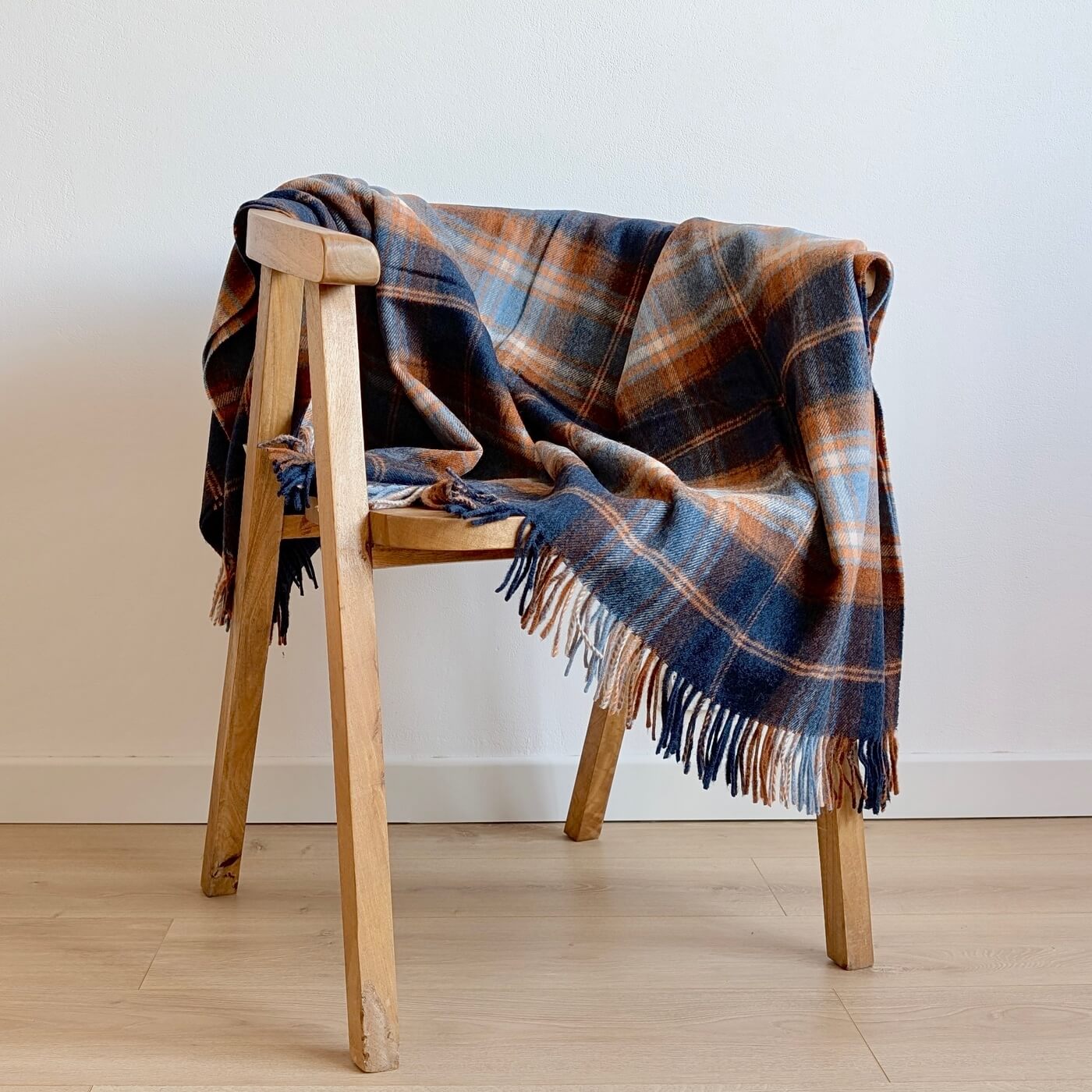 Pătură 100% lână Merino Winterton, Navy - model în carouri britanică - bleumarin și maro - pe scaun