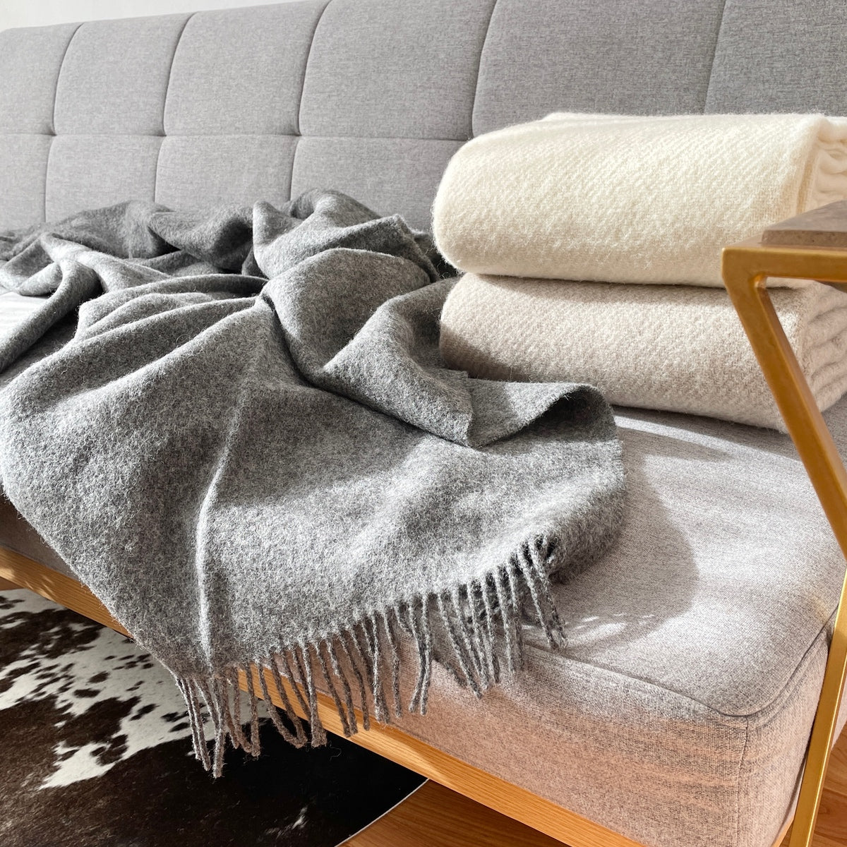 patura gri 100% din lana de merino Milan, pe canapea