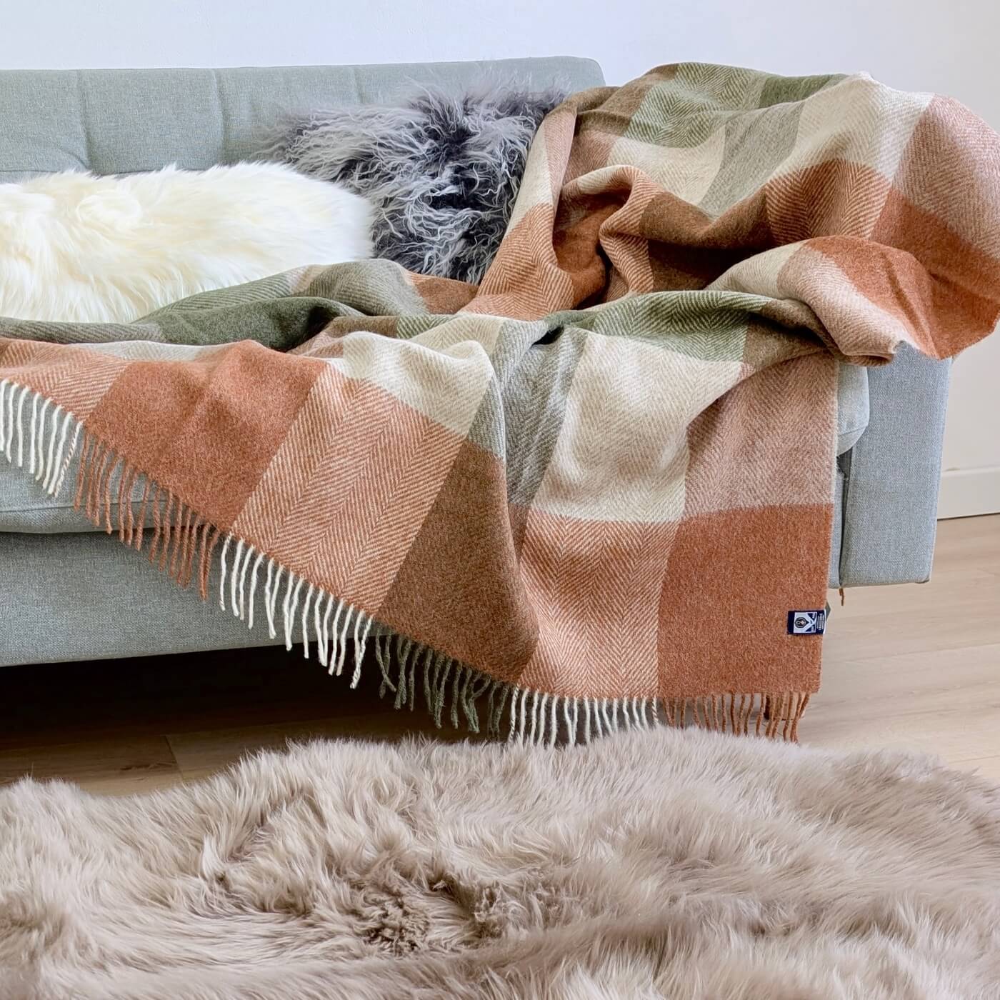 Pătură 100% din lână pură nouă Block Check, Teracota / Verde Salvie - pe canapea