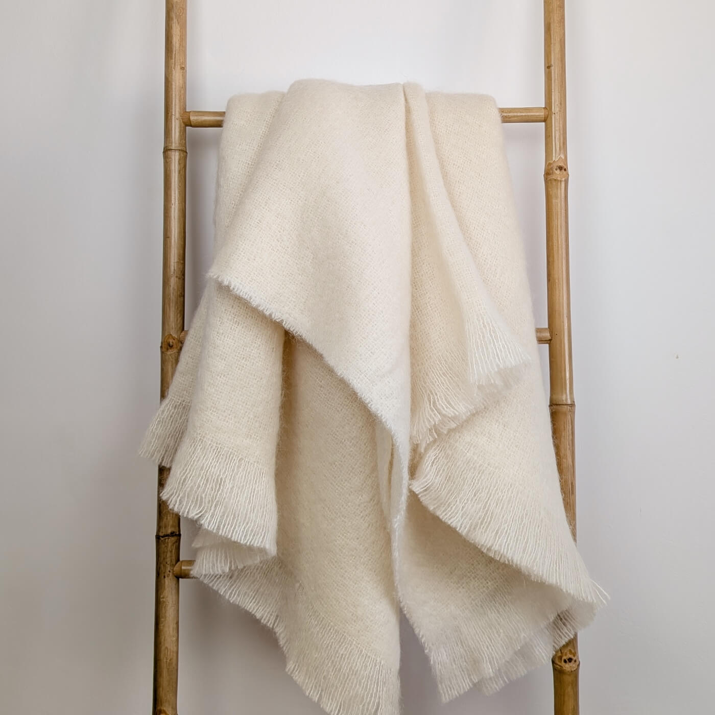 Pătură din mohair superfin model simplu într-o singură culoare alb-gălbui, pe scară