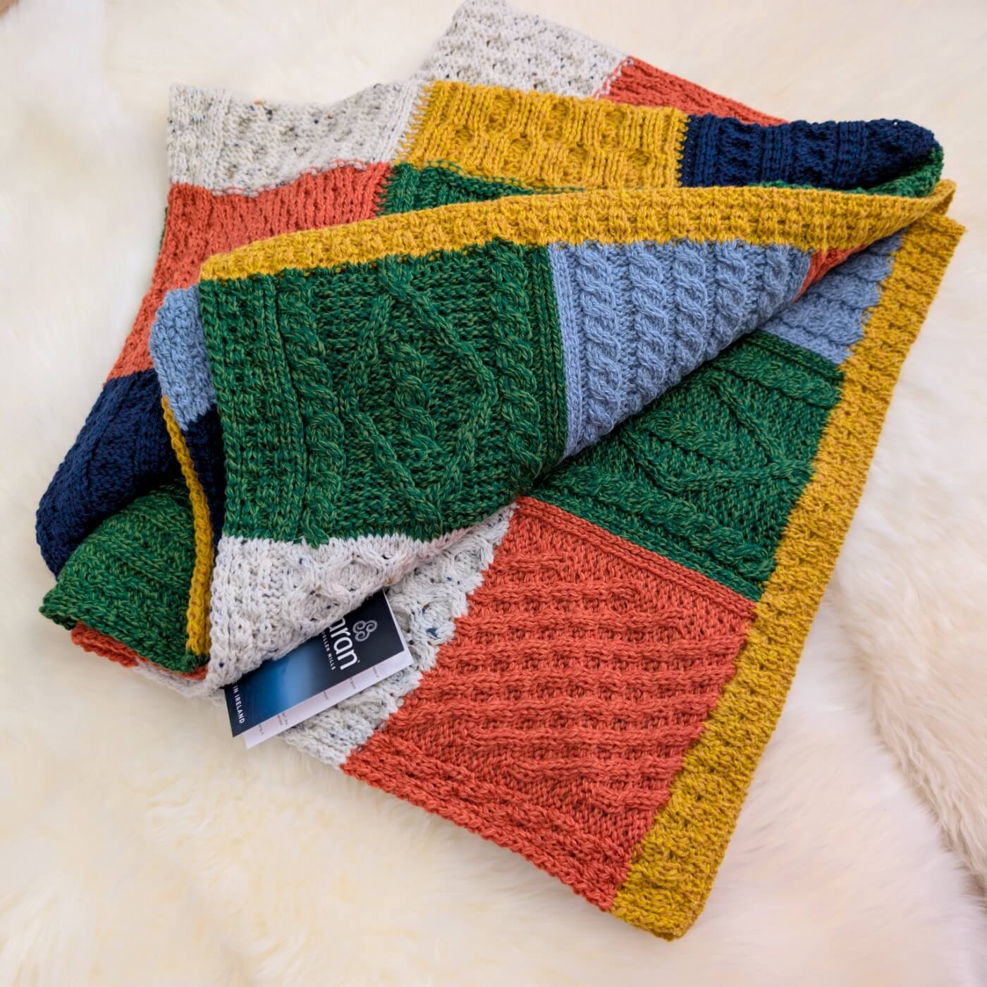 pătură tricotată lână merino supersoft Killala Aran, model carouri din pătrate, multicoloră, corșetată în Irlanda
