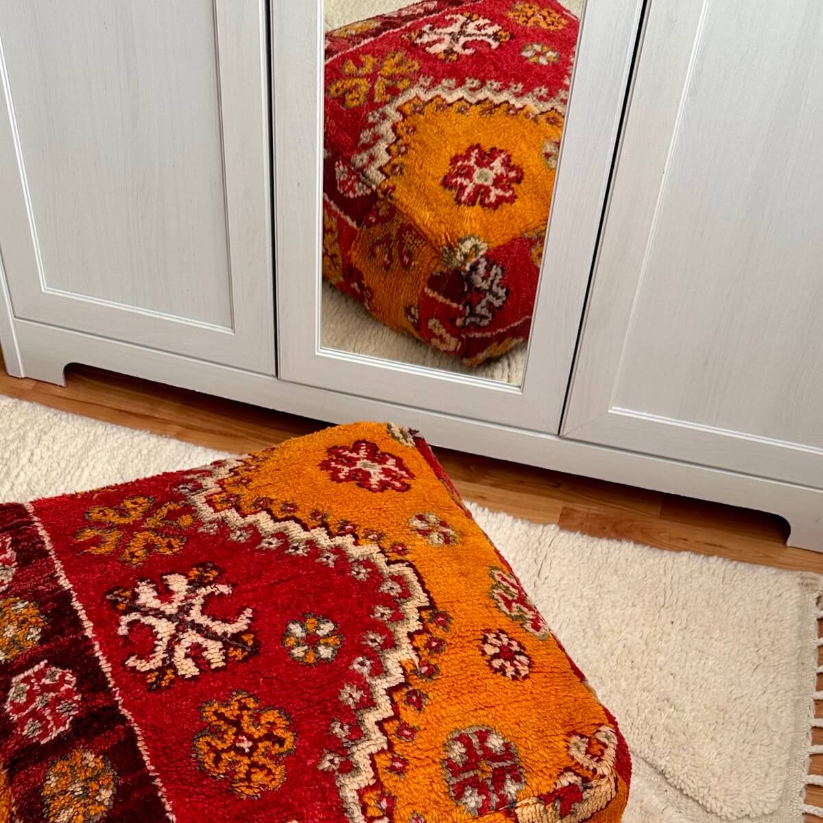 perna de podea marocana vintage creata dintr-un covor din lana multicolor