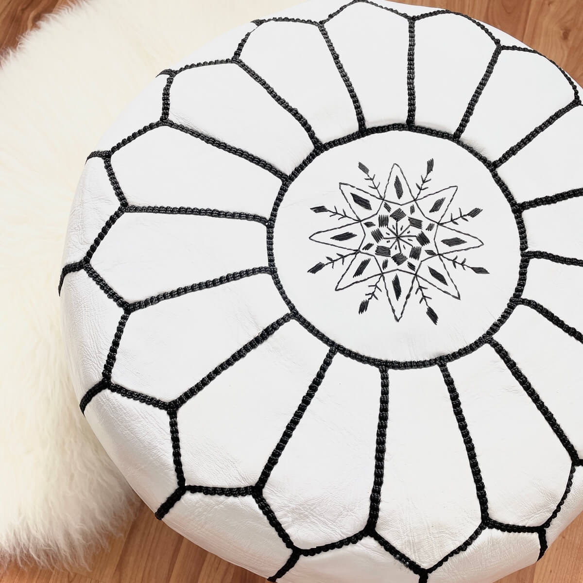 puf marocan din piele naturala, culoare  alba cu cusatura neagra, pe podea