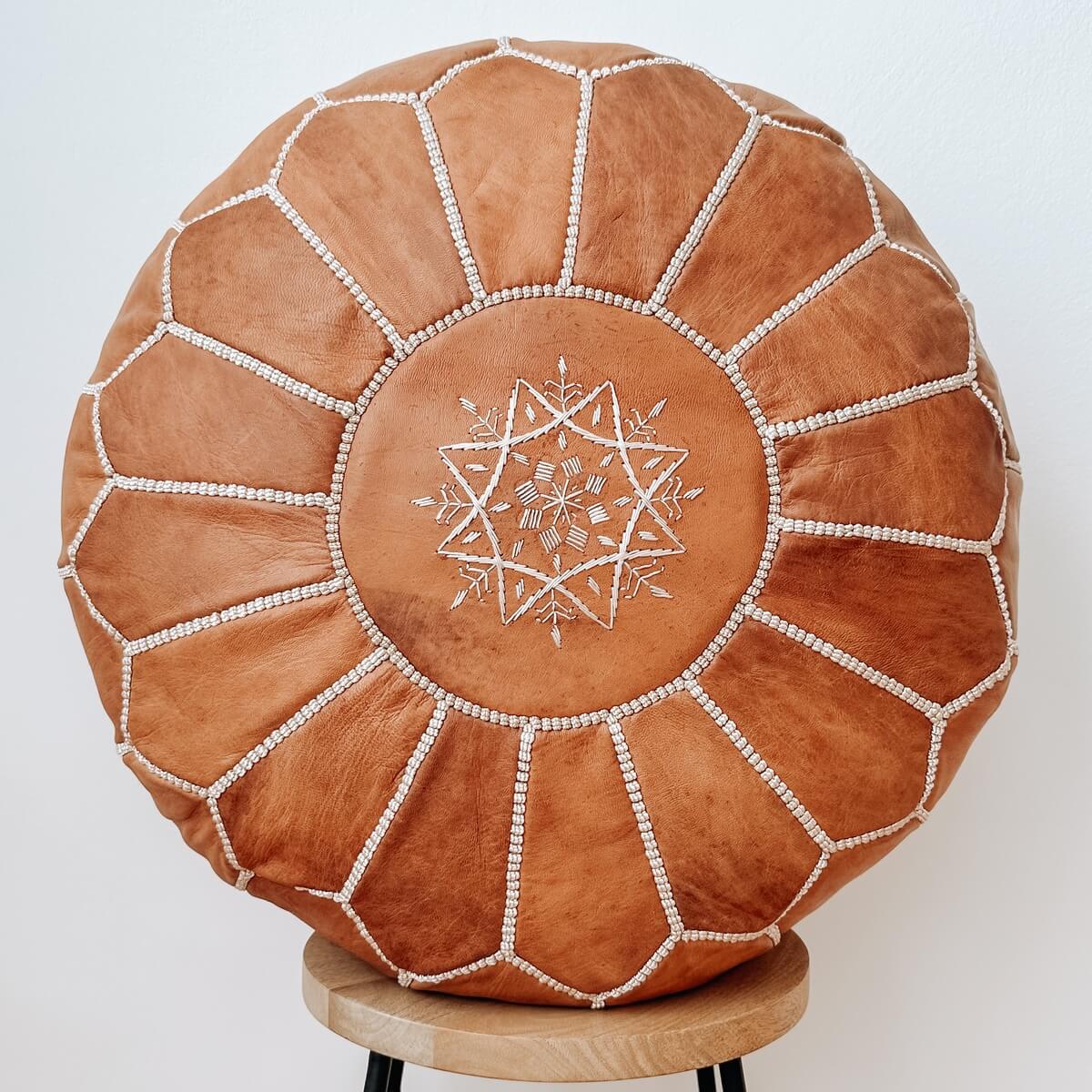 pouf marocan din piele naturala cusut manual de culoare maro deschis, pe scaun